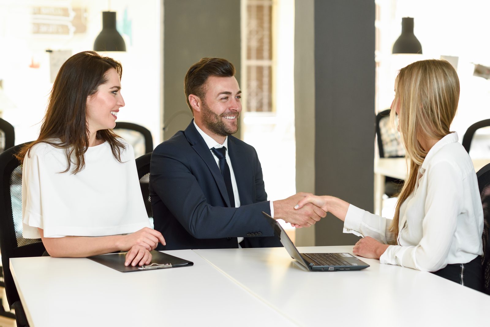 smiling-young-couple-shaking-hands-with-insurance-agent.jpg